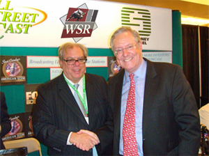 Alan Stone shaking hands at a Forbes event booth