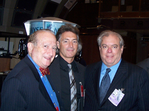 Three men in suits at an investor forum reception
