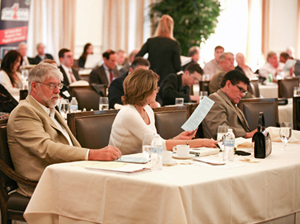 Investors seated at tables during a South Florida Investment Forum presentation